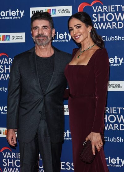 Simon Cowell and Lauren Silverman smiling on the red carpet