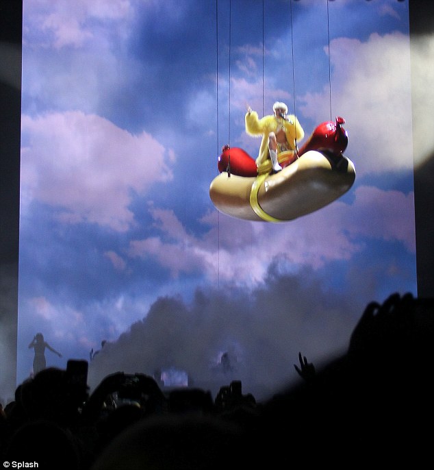 I'm up here: The singer swings high above the audience gathered inside Anaheim's Hona Center