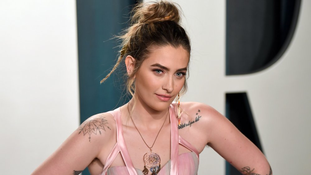 Paris Jackson with shoulder tattoos and hair in a bun