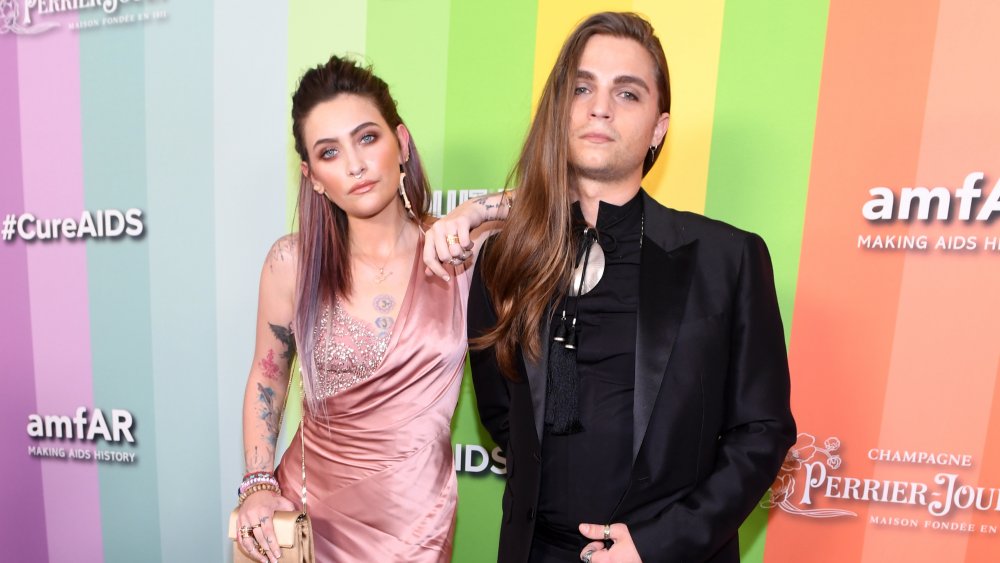 Paris Jackson and Gabriel Glenn posing together in front of #Cure AIDS wall