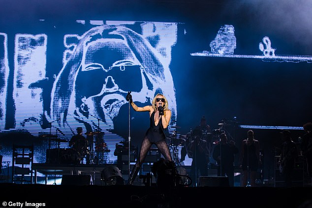 Paying tribute: During her performance, Miley took a seat on a stool and sang Angels Like You in front of a backdrop featuring a photo of Taylor