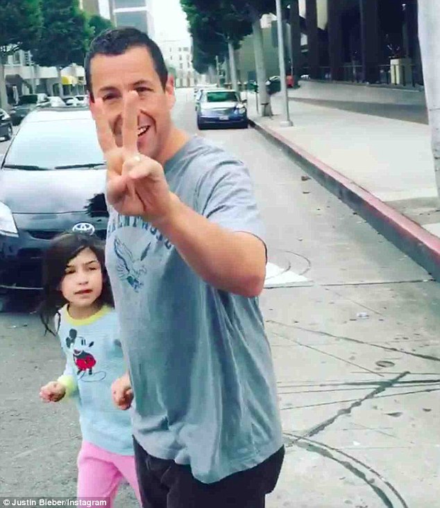 'Living legend': The comedian flashed a peace sign before heading on his way with his daughter Sunny