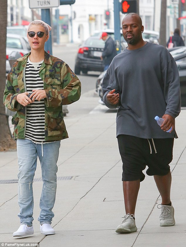 Chilled vibes: He kept a bit of his skater look with white Vans slip ons, while rocking a pale pink beanie over his newly dyed purple hairdo