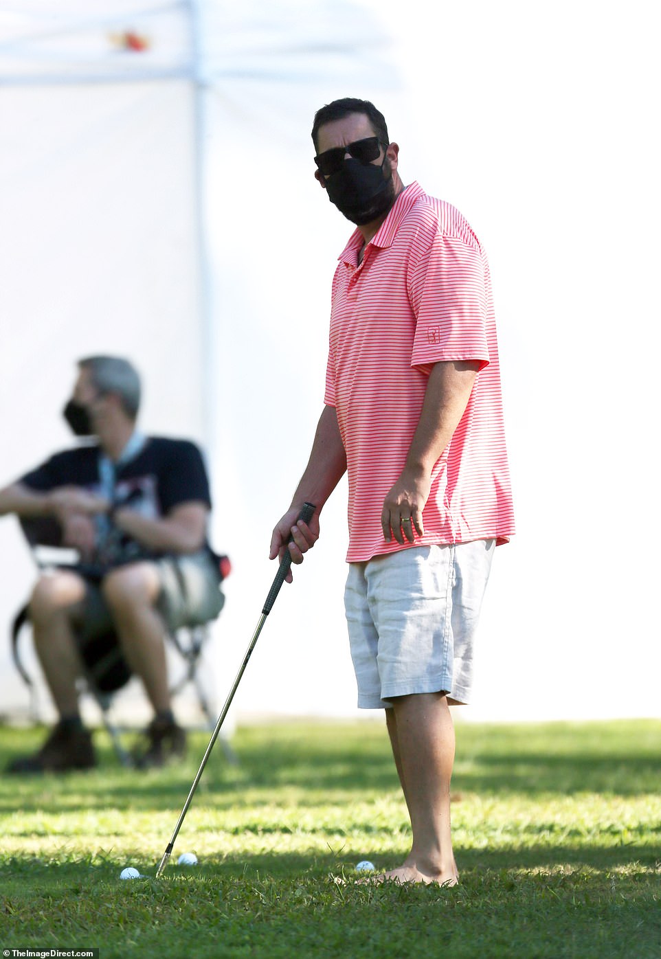 Linking up! Sandler wore his face mask as he partook in a round of golf.