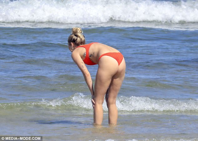 Cheeky! Miley was spotted taking a quick dip in a retro-inspired red bikini