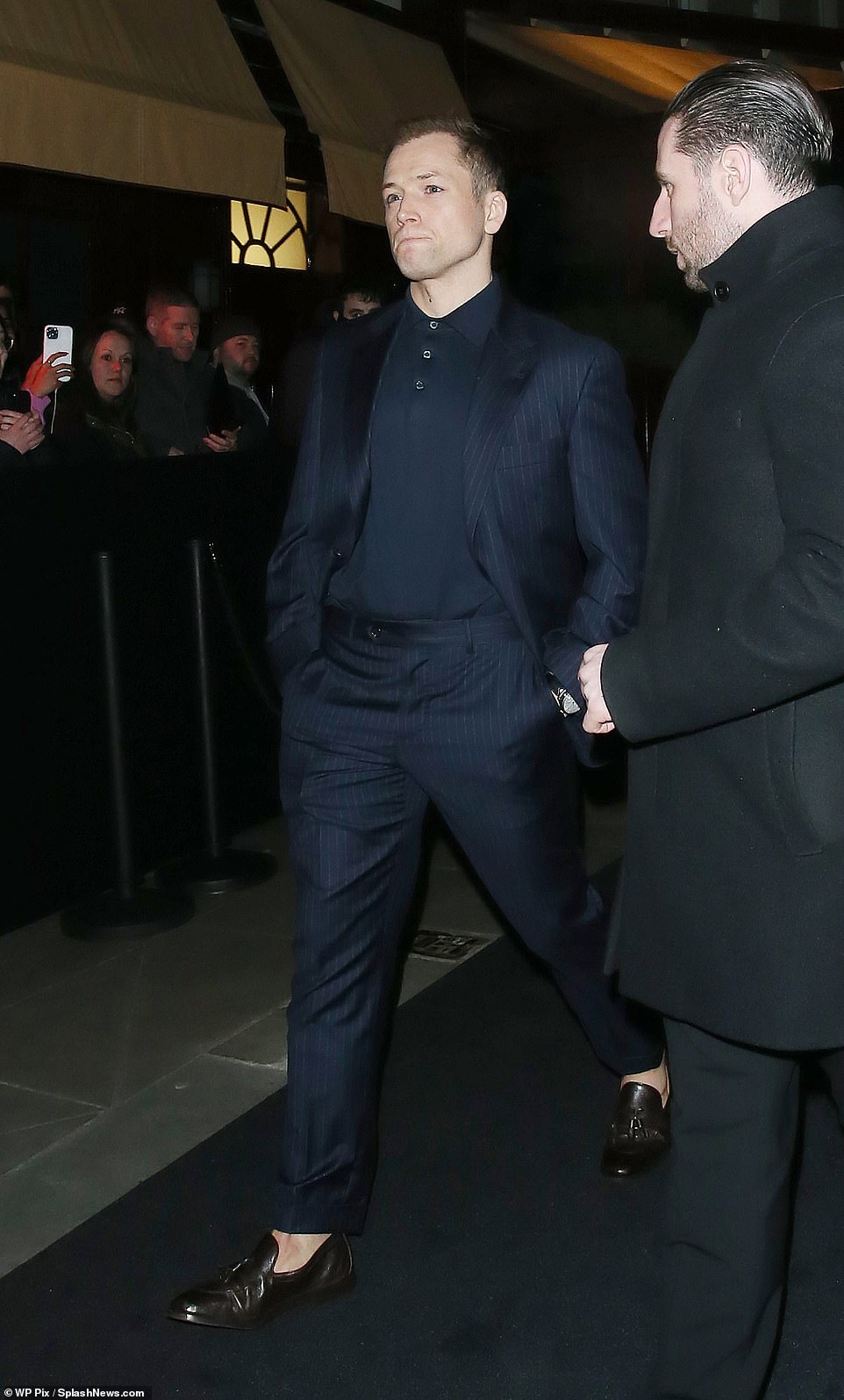 Smart: Taron Egerton sported a navy blazer and trousers with a matching polo shirt