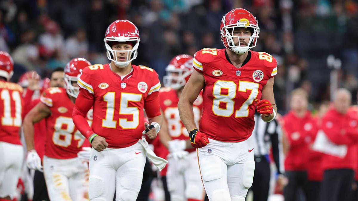 Travis Kelce and Patrick Mahomes jog on the football field