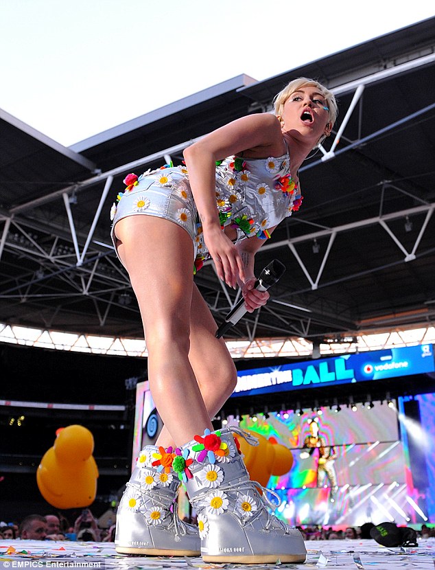 She's on another planet: Miley wore a pair of large silver moon boots that were also covered in flowers