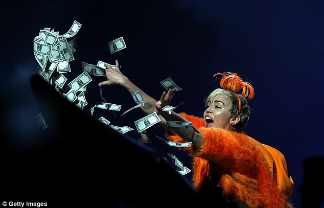 Dollar signs: Miley tossed fake money into the crowd, potentially exciting fans who mistook it for real cash