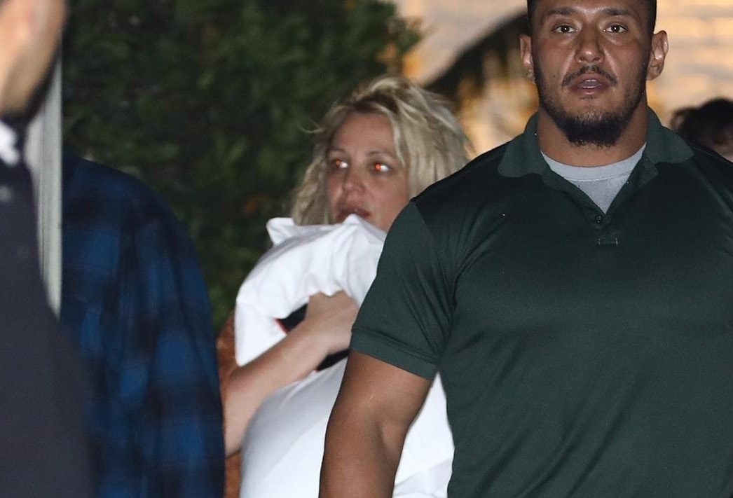 Britney Spears wears a pillow to cover up, as Paul Richard Soliz walks in front of her.