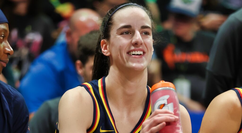 Caitlin Clark looks on from the bench during a game.