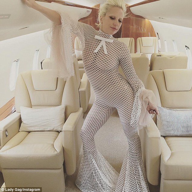 Interesting choice of travel attire: Lady Gaga dared to go almost bare in a white jumpsuit perforated with holes that clearly revealed her boobs as she flew on a private jet, which she posted on Instagram on Monday