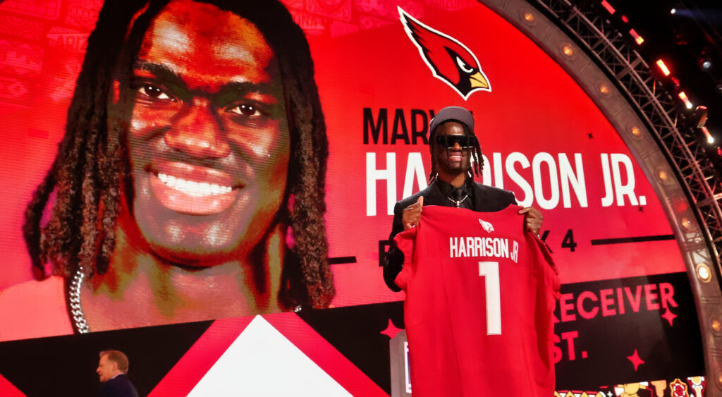 Marvin Harrison Jr. holding up his Cardinals jersey