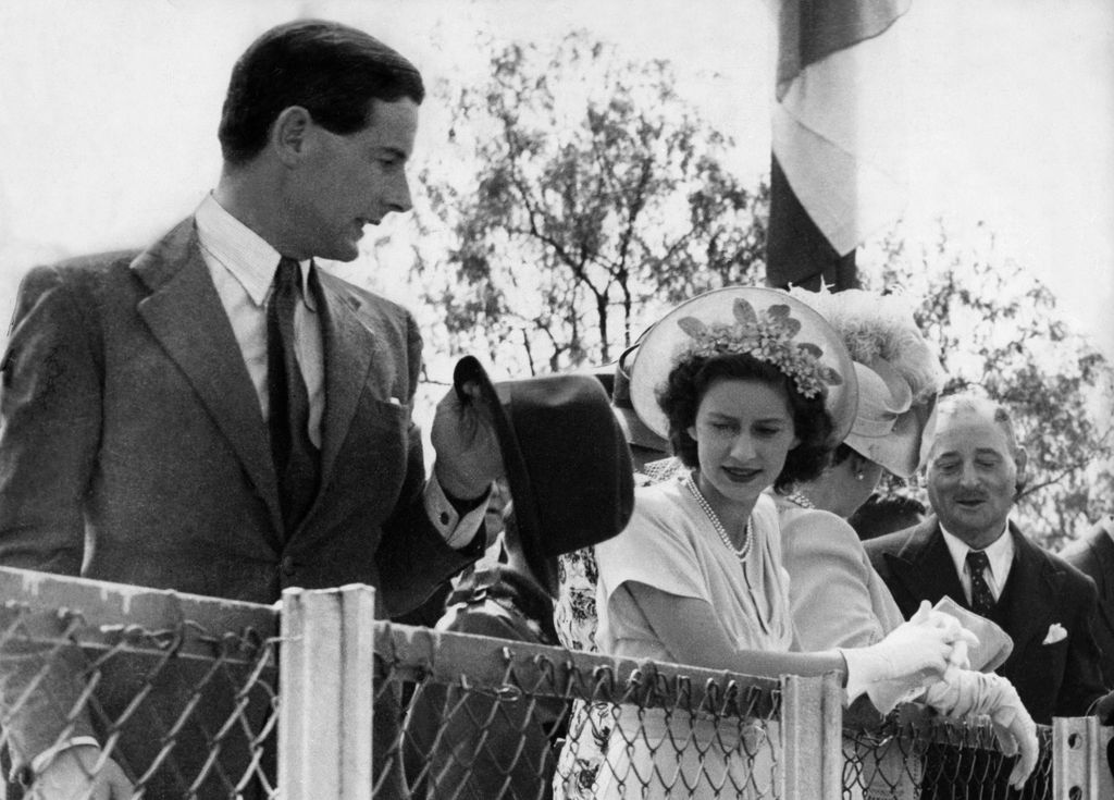 Princess Margaret in a floral hat next to suit-clad Peter Townsend in 1955