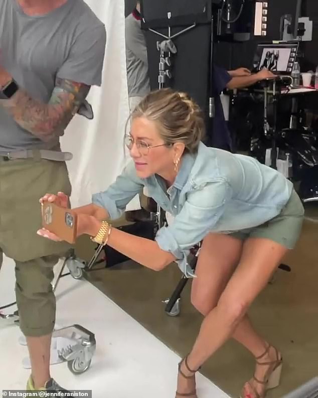 Capturing the moment: She was seen sporting sage green shorts which she teamed with a denim shirt for her day at the studio as she tucked her flaxen tresses up in a bun