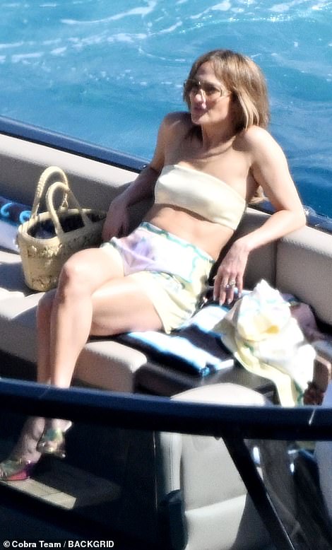 The actress, 54, flashed her toned abs and enviable legs as she donned a pastel yellow crop-top paired with matching shorts for a relaxing yacht break.