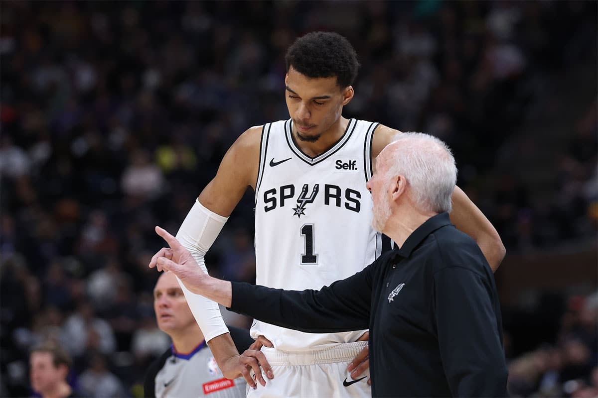 San Antonio Spurs center Victor Wembanyama (1) and head coach Gregg Popovich speak during a break in action against the Utah Jazz during the third quarter at Delta Center. 