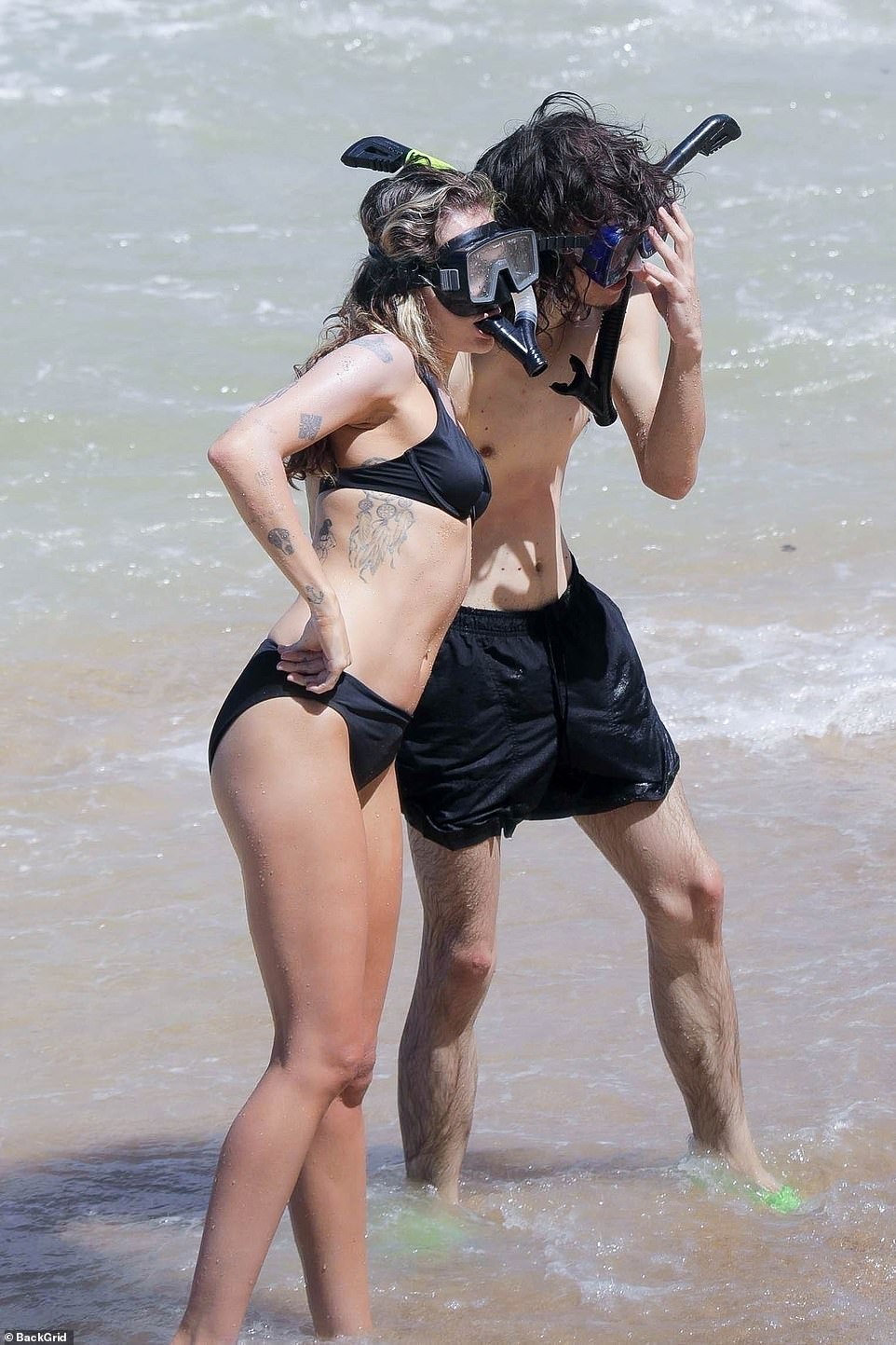 Posing in the shore: Miley and Maxx seemed to be posing for a photo before they headed out into the ocean