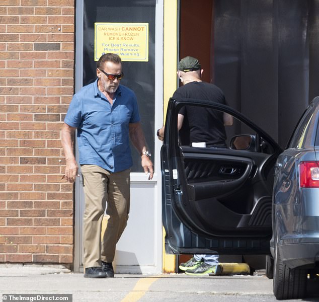 Arnold's look: Schwarzenegger was spotted wearing an azure blue button-down shirt and orange sunglasses with black frames