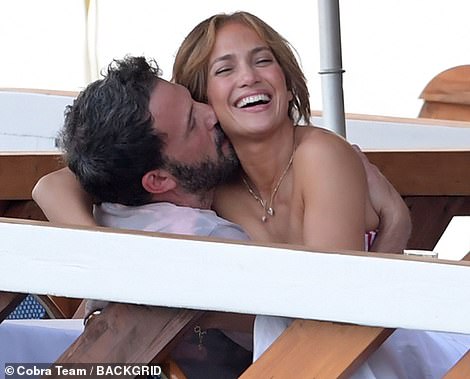 Besotted! The actress, 52, beamed a smile as the actor kissed her neck and wrapped his arms around her