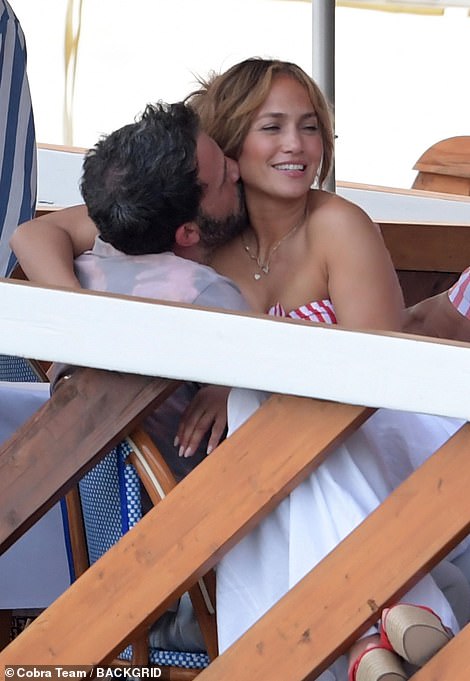 Want to get any closer? Jennifer cosied into her love, resting her heeled shoes on the restaurant's wooded divider