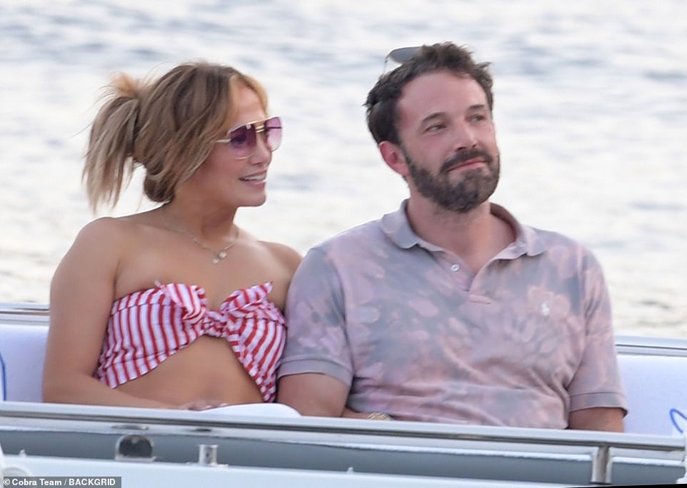 Happy as can be: The loved-up couple cosied up together on the boat ride to the restaurant, even linking arms as they chatted