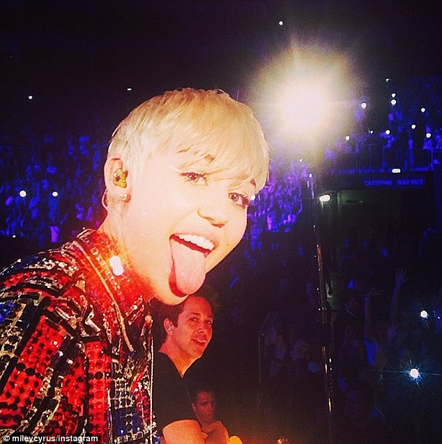 Still with the tongue: Miley took a selfie onstage during the gig