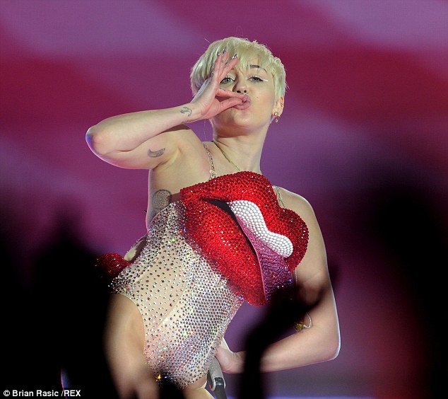 Tut tut! Miley pretended to smoke on stage - as she continued to be controversial