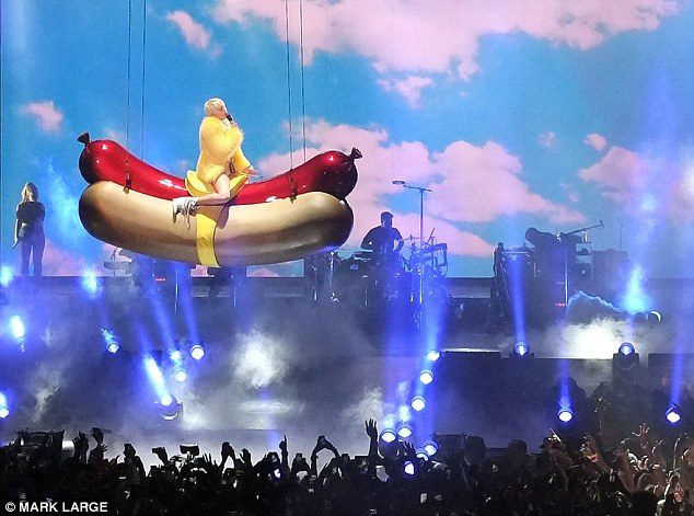 Flying high: The star descended above the crowds on the giant sausage