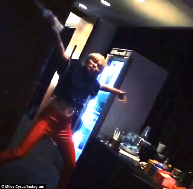 Miley just being Miley! Cyrus is seen throwing flowers and water around backstage in a new video