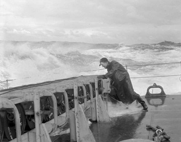 A sailor checks the stowage of the depth charges aboard the HMCS Matane, 1944. 