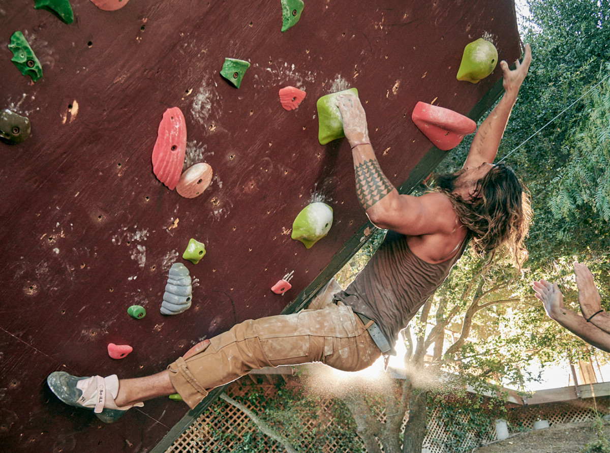 Jason Momoa using his climbing wall in his backyard.