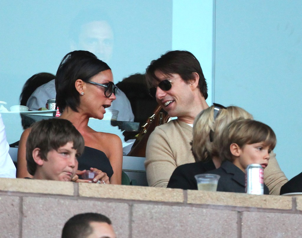 Victoria Beckham talks to Tom Cruise, as Romeo Beckham sits on his grandma Sandra Beckham's lap.