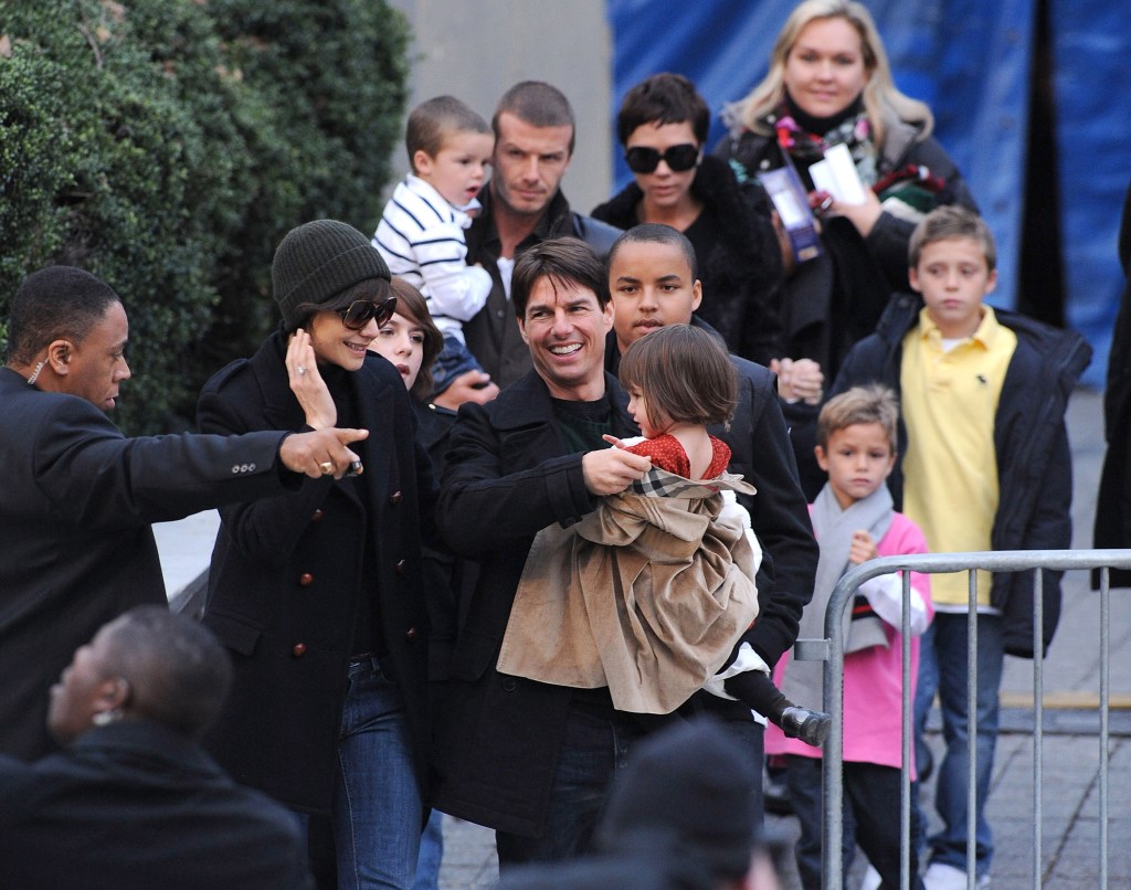 Tom Cruise holds Suri Cruise, with Katie Holmes next to him. Joined by Connor and Isabella Cruise. David Beckham holds Cruz Beckham, while Victoria Beckham holds hands with Brooklyn Beckham.