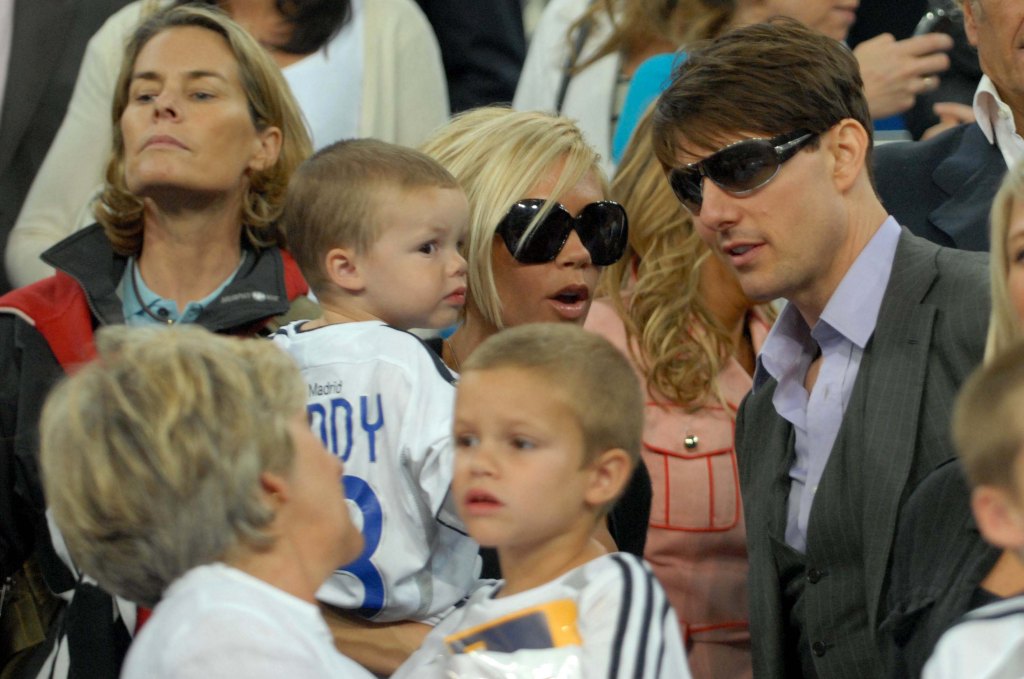 Tom Cruise talks to Victoria Beckham - holding Cruz Beckham. Sandra Beckham holds Romeo Beckham.