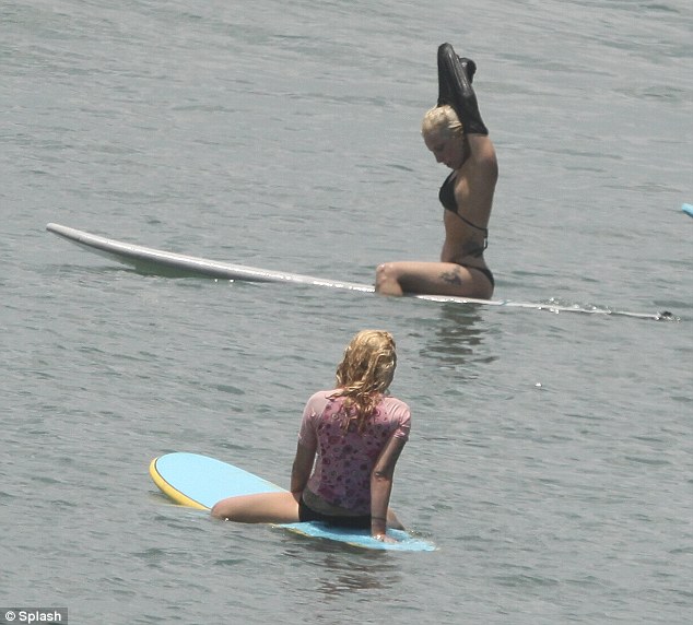 Let's get wet: The superstar removed her wetsuit and carried on surfing in her bikini