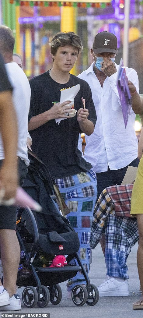 Snack time: Cruz then grabbed a bite to eat, snacking on a cone of chips as he walked alongside his dad