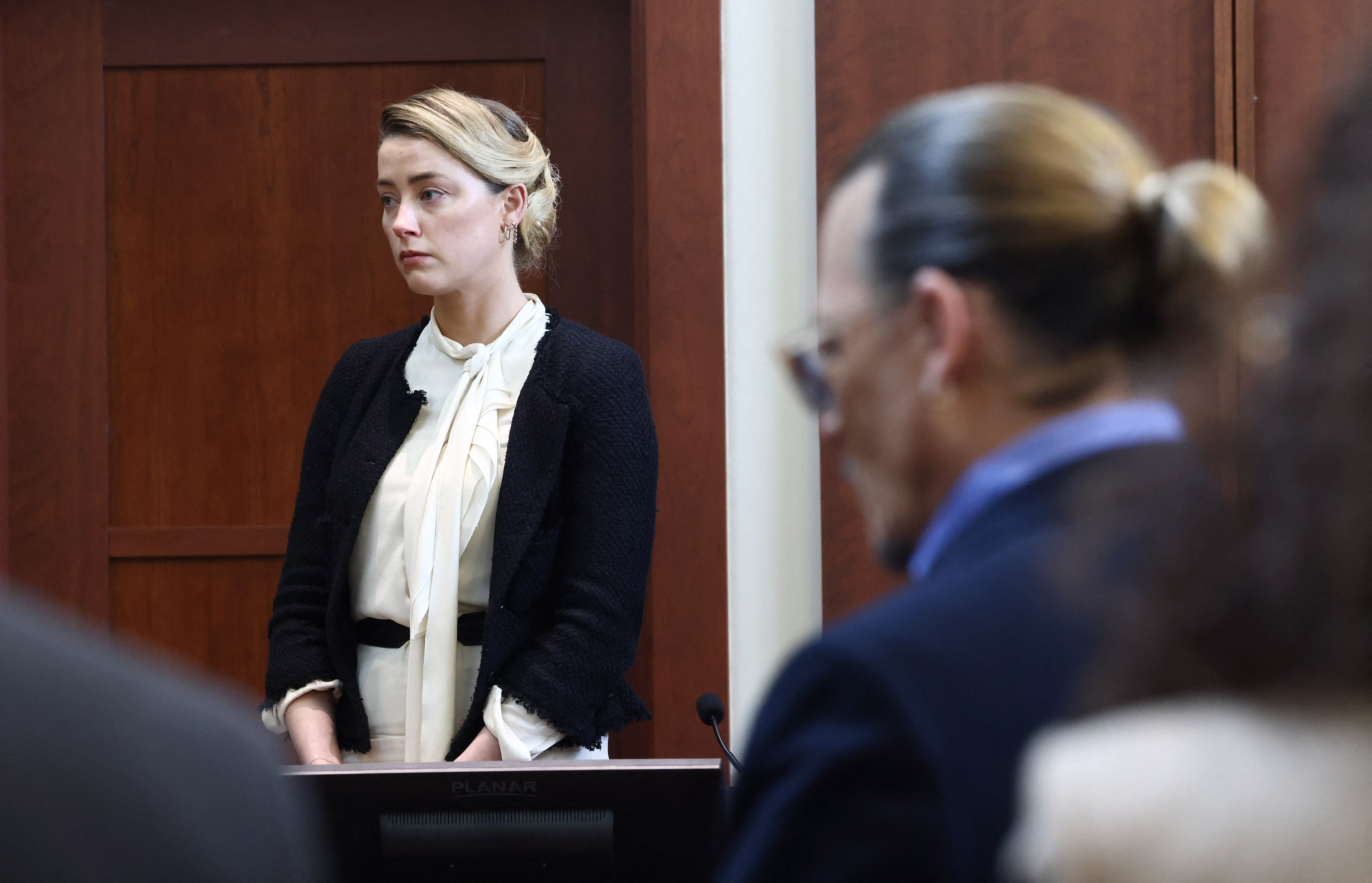 Amber Heard testifies as US actor Johnny Depp looks on during their defamation trial in May 2022