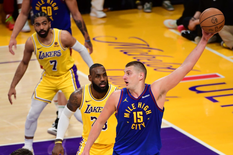 LOS ANGELES, CA - APRIL 25: Nikola Jokic #15 of the Denver Nuggets handles the ball while LeBron James #23 of the Los Angeles Lakers plays defense during the game during Round One Game Three of the 2024 NBA Playoffs on April 25, 2024 at Crypto.Com Arena in Los Angeles, California. NOTE TO USER: User expressly acknowledges and agrees that, by downloading and/or using this Photograph, user is consenting to the terms and conditions of the Getty Images License Agreement. Mandatory Copyright Notice: Copyright 2024 NBAE (Photo by Adam Pantozzi/NBAE via Getty Images)