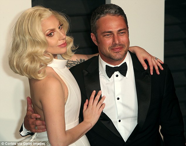 Split: Gaga with then-fiance Taylor Kinney at a post-Oscars party in February. The singer has denied Perfect Illusion is about her ex, calling him her 'best friend'