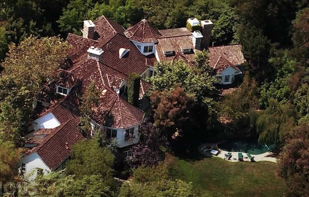 aerial view of Adam Sandler's house in Los Angeles, showing the roof and turrets of the house along with parts of the pool