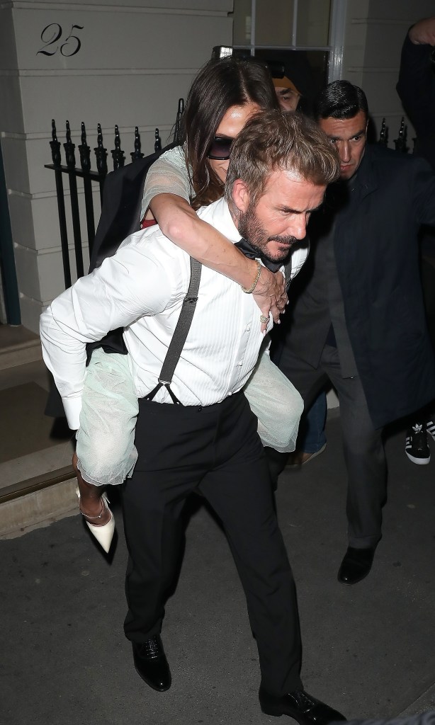 David Beckham giving Victoria Beckham a piggy back ride.