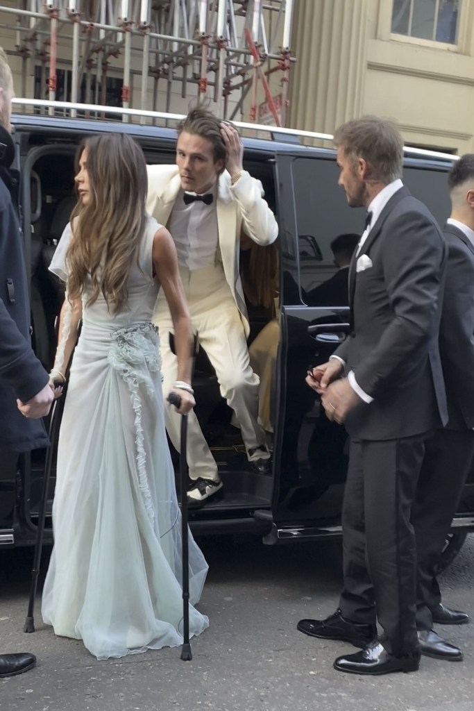 Victoria Beckham on crutches, Brooklyn Beckham getting out of the car and David Beckham standing by the car.