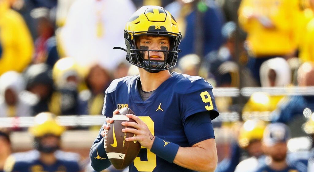 JJ McCarthy of Michigan Wolverines holding football.