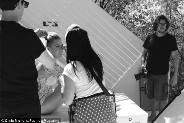 Even superstars need a touch up: Miley gets her make-up fixed between takes on the set of her photo shoot