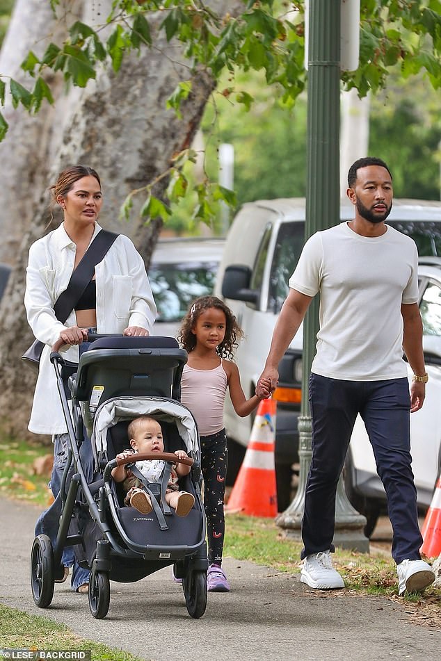 John's look: Her husband Legend opted for a plain white top with dark blue pants and pristine white sneakers for the outing