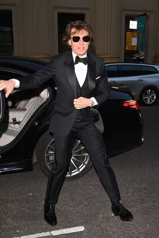 Tom Cruise beside a car