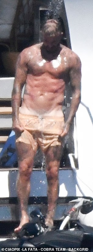 The former footballer, 49, put his ripped figure on display as he went shirtless in a pair of lemon yellow swimming trunks before slipping on a life jacket to hop on a jet ski