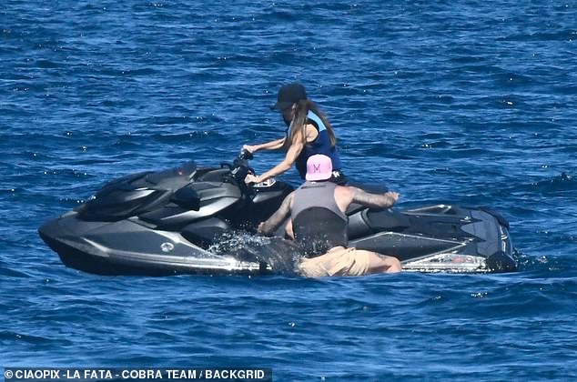 David was seen scrabbling around trying to make it onto the jet ski to sit behind his wife