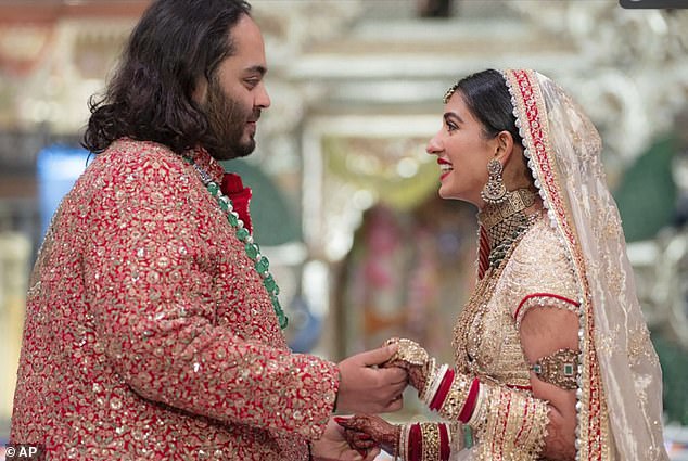 Anant Ambani, left, the son of billionaire Mukesh Ambani, holds hands with Radhika Merchant during their wedding ceremony at Jio World Convention Centre in Mumbai, India, Friday, July 12, 2024